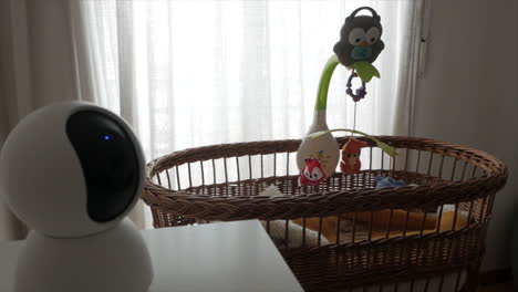 Surveillance-Camera-in-foreground,-baby-crib-with-rotation-musical-toy