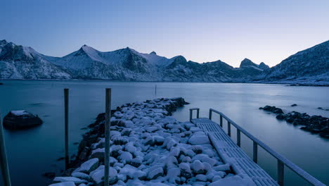 Zeitraffer-Eines-Fjords-Während-Der-Morgendlichen-Blauen-Stunde-In-Norwegen-An-Einem-Steg-Mit-Bergen-Im-Hintergrund-Im-Winter