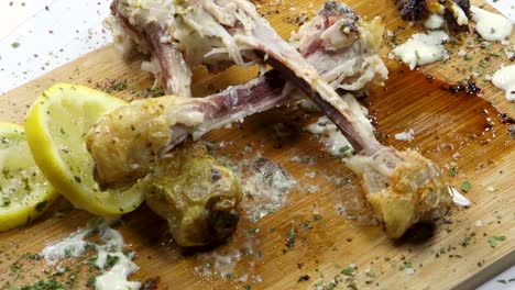 Hand-picking-up-bones-of-eaten-chicken-with-leftovers-of-meat