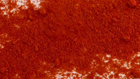 Cayena-Roja,-Especias-En-Polvo-De-Pimentón-Que-Caen-En-Una-Superficie-Blanca