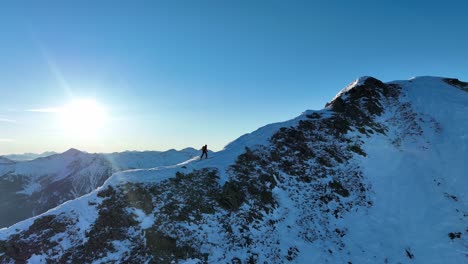 Esquiador-Alpino-En-Una-Cresta-Con-Sus-Esquís-Durante-El-Ascenso