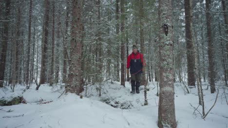 Norwegian-Backpacker-With-His-Dog-On-Snow-Covered-Forest