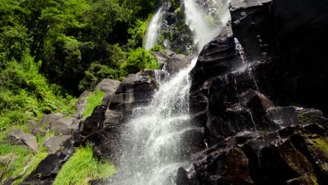 Handheld-Von-Salto-Niña-Encantada-Nebliger-Wasserfall,-Der-Eine-Felswand-Hinabströmt,-Umgeben-Von-Dichtem-Regenwald-In-Liquiñe,-Chile
