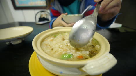 Delicious-Rice-and-vegetable-kanji-porridge-soup-being-stirred-with-spoon