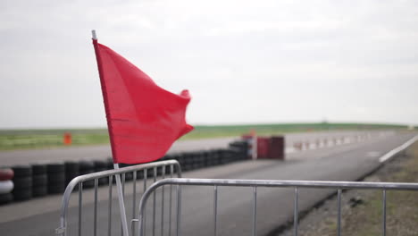 Red-Flag-waving-in-the-wind-on-a-Racing-track