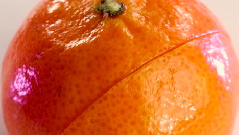 Very-sharp-knife-cutting-the-surface-of-a-tangerine