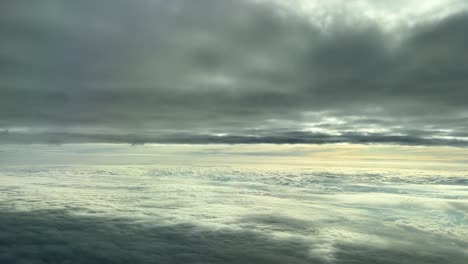 Aerian-view-from-a-cockpit-flying-between-cloud-layers-in-the-sunset-,-white-and-gray-clouds