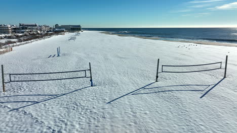 Beach-volleyball-court-nets-on-sandy-beachfront-covered-in-snow