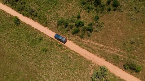 Truck-driving-a-dirt-road,-aerial-drone-follow-shot