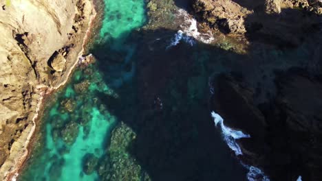 Fliegen-über-Kristallblaues-Wasser-Und-Felsiges-Riff,-Das-Auf-Die-Küste-Der-Pazifischen-Insel-Bricht