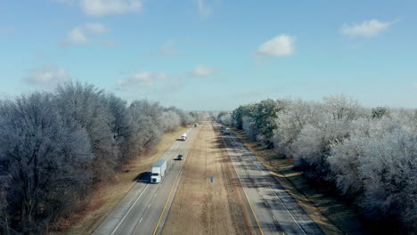 Slowly-rising-aerial-over-rural-stretch-of-interstate-highway-in-winter,-4K