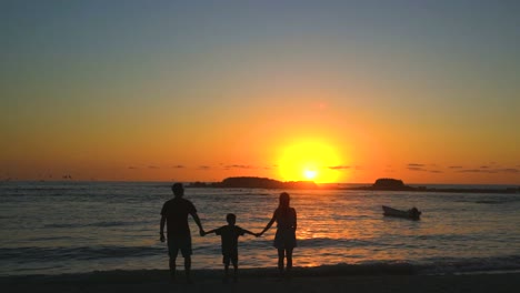 Familie-Im-Strandurlaub,-Der-Einen-Ruhigen-Und-Entspannenden-Sonnenuntergang-Am-Meer-Genießt