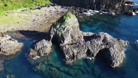 Ruhiges,-Kristallblaues-Wasser,-Das-Die-Felsen-Umgibt,-Die-An-Der-Küste-Der-Pazifischen-Insel-Herausragen