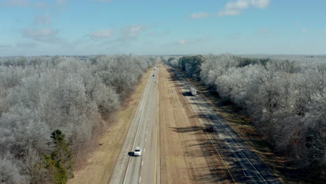 Aerial-view-moving-along-remote-stretch-of-interstate-highway-with-trucks,-4K