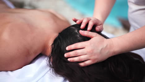 Slow-motion-black-skin-young-athletic-woman-receiving-a-relaxing-deep-tissue-massage-from-a-professional-female-therapist-in-luxury-spa