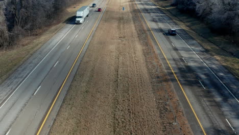 Static-drone-aerial-view-panning-up-to-rural-interstate-highway-road,-4K