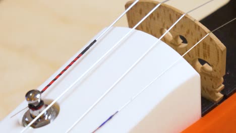 Close-up-shot-of-finger-touching-strings-of-3D-printed-violin