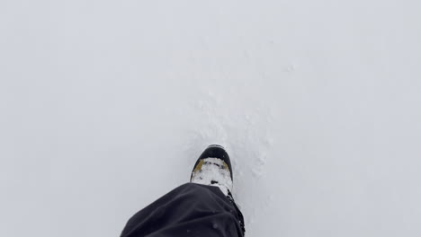 A-first-person-view-shoot-of-a-pair-of-boots-walking-on-snow-and-show-beautiful-winter-scenery,-wearing-hiking-boots-and-trousers