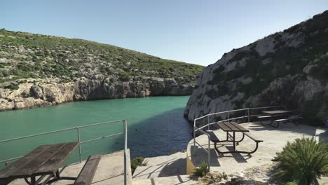 Empty-Tables-with-Seats-on-Magrr-Ix-Xini-Bay-on-Sunny-Day-in-Gozo-Island