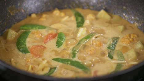 Karotten-Und-Grüne-Erbsen-Kochen-In-Einem-Thailändischen-Gelben-Kokosnuss-Curry,-Vegetarisches-Veganes-Thailändisches-Essen