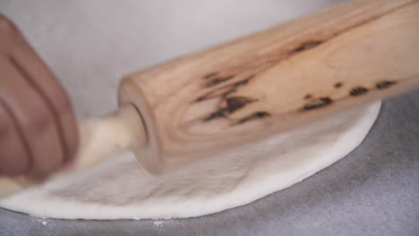 Rolling-Out-White-Dough-with-a-Wooden-Rolling-Pin,-Preparing-Dough-for-Baking,-Close-Up