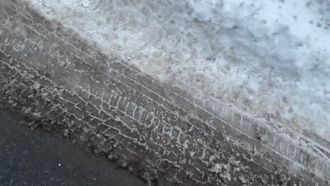 Schmutzige,-Schlammige,-Kompakte-Schneereifenspuren-Von-Autoreifen-Auf-Der-Straße-Im-Winter,-Wobei-Der-Schnee-Zu-Schneematsch-Schmilzt,-Wenn-Der-Frühling-In-Kanada-Kommt