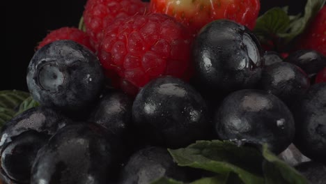 Unglaublich-Saftige-Makroansicht-Von-Rotierenden-Waldfrüchten-Mit-Schwarzem-Hintergrund,-Erdbeeren,-Blaubeeren,-Himbeeren,-Gesunde-Früchte,-4k-aufnahme