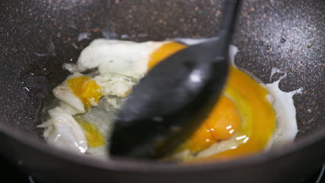 Scrambling-Eggs-in-a-Black-Pan,-Scrambled-Eggs,-Mixing-Egg-White-and-Egg-Yolk-in-a-Pan