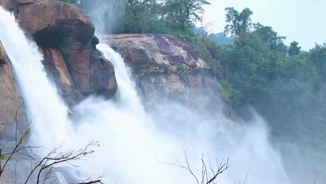 Cascada-Agua-Que-Fluye-Brumosa-Que-Cae-Desde-La-Cima-De-La-Montaña-En-El-Video-Matutino-Tomado-En-La-Cascada-Athirapally-Kerala-India