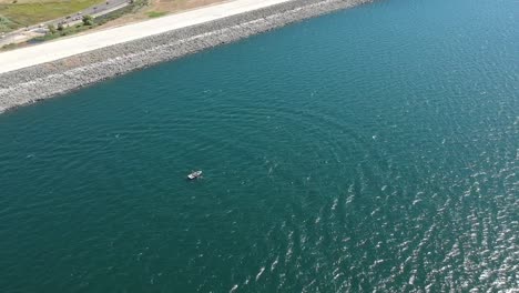 Aerial-view-boat-navigating-in-Folsom-lake,-El-Dorado-county,-California