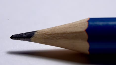 Schließen-Sie-Herauf-Hölzernen-Bleistift,-Der-Auf-Einem-Weißen-Blatt-Papier-Rollt