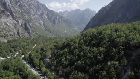 Drone-video-of-the-plane-Discovery-plane-on-the-Azem-Hajdari-road-between-the-mountains-at-the-height-of-the-Rragam-i-Shalese-village-in-the-Valbona-valley-and-the-Rrogam-i-Shales-river