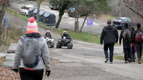 View-of-some-people-hiking-down-a-road-where-a-couple-of-quad-bikes-appear-and-stop-to-discuss-the-route-to-take