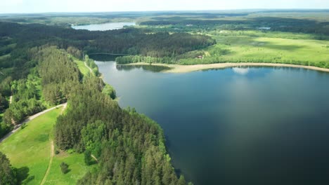 AERIAL:-Flying-Over-Majestic-Lake-Over-Forest-on-Sunny-Summer-Day