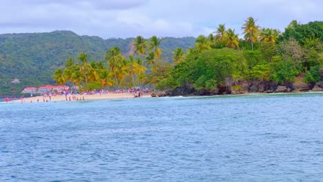 People-on-beach-of-Cayo-Levantado-or-Bacardi-island-seen-from-boat-during-navigation,-Samana-in-Dominican-Republic
