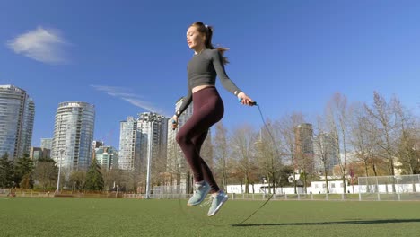 Fit-athletic-young-woman-training-skipping-in-city-park