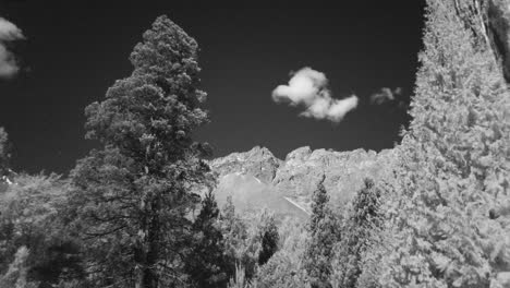 Infrared-Landscape,-Timelapse-Of-Clouds-In-The-Mountains-Of-The-Piltriquitron-Hill,-Patagonia,-Framed-By-Tree,-wide-shoot