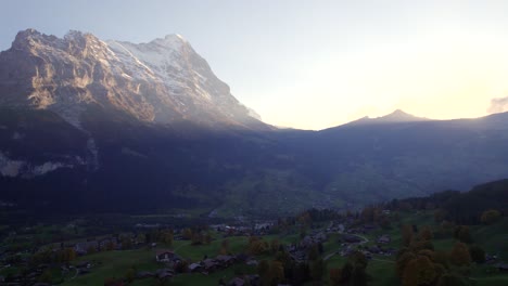 aerial-drone-footage-dolly-left-to-right,-Grindelwald-village-and-Eiger-North-Face-at-sunset-in-Autumn