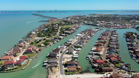 Aerial-video-of-Port-Isabel,-Texas-with-a-view-of-the-Laguna-Madre,-the-causeway-and-South-Padre-Island-on-the-back,-with-two-boats-driving-around-on-the-video