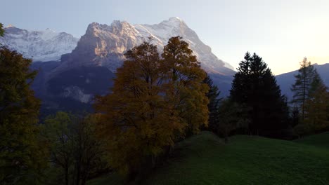 aerial-drone-footage-rising-up-revealing-dreamy-view-of-Grindelwald-village-and-Eiger-North-Face-in-autumn-sunset