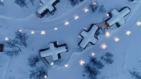 Snow-covered-roofs-with-cross-shape-huts-in-Snowhotel-Kirkenes,-Norway