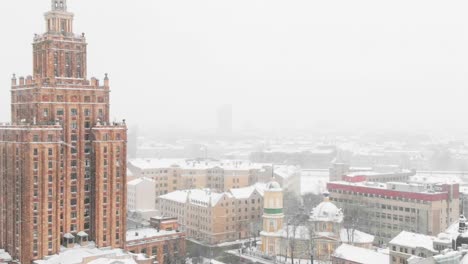 Latvian-Academy-of-Sciences-in-winter-snowfall,-aerial-drone-view