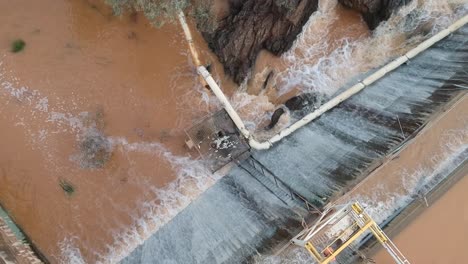 -Flood-waters-cascading-over-a-dam-wall-from-a-drone-7