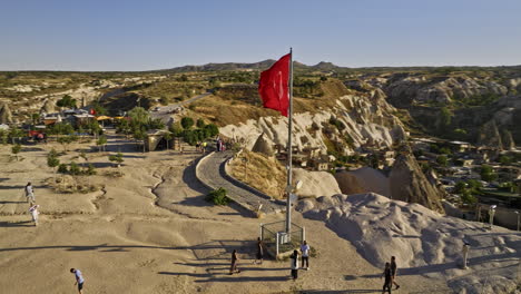 Göreme-Turkey-Aerial-v18-low-fly-around-turkish-flag-on-high-plateau-view-point-capturing-panoramic-view-of-ancient-cave-town-and-landscape-of-rock-formations---Shot-with-Mavic-3-Cine---July-2022