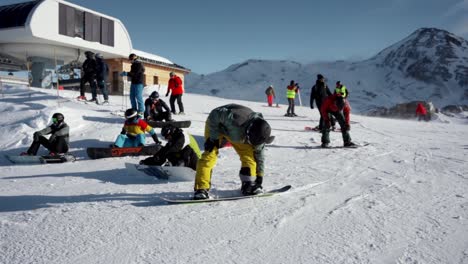 Snowboarders-Abrochando-Botas-Antes-De-Bajar-La-Pendiente-En-Invierno