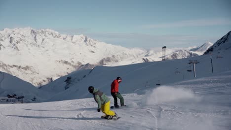 Gente-Haciendo-Snowboard-Por-La-Ladera-De-Las-Montañas-Durante-El-Invierno