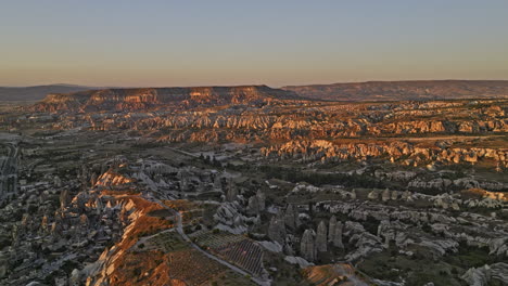 Göreme-Turkey-Aerial-v27-landscape-of-spectacular-rock-formation-caused-by-volcanic-eruption,-unique-landform-of-mesa-mountain,-fairy-chimney-and-plateau-at-sunset---Shot-with-Mavic-3-Cine---July-2022