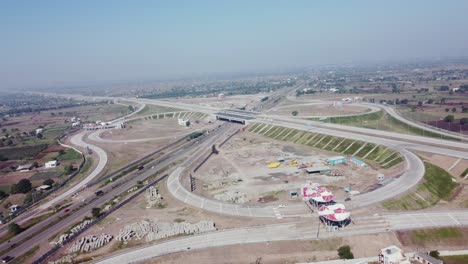 Orbiting-aerial-drone-view-of-the-Interchange-of-Samruddhi-Mahamarg-also-known-as-Nagpur-to-Mumbai-Super-Communication-Expressway,-an-under-construction-6-lane-highway