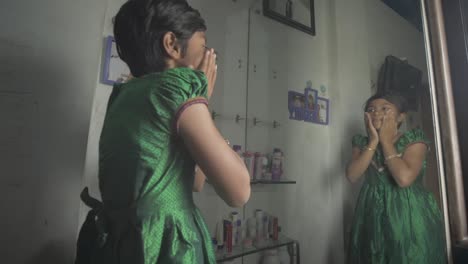 Teenage-girl-with-boy-cut-hair-standing-in-front-of-the-mirror-wearing-a-beautiful-green-dress-and-applying-makeup