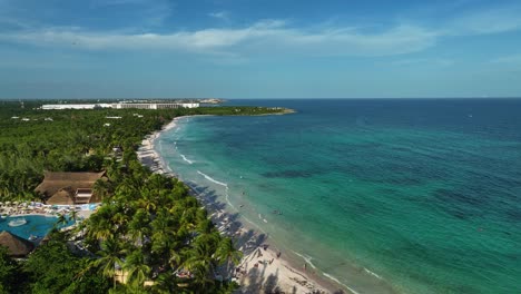 Aerial-view-around-calm-waves-at-a-tropical-beach-in-Xpu-Ha,-Mexico---panoramic,-drone-shot